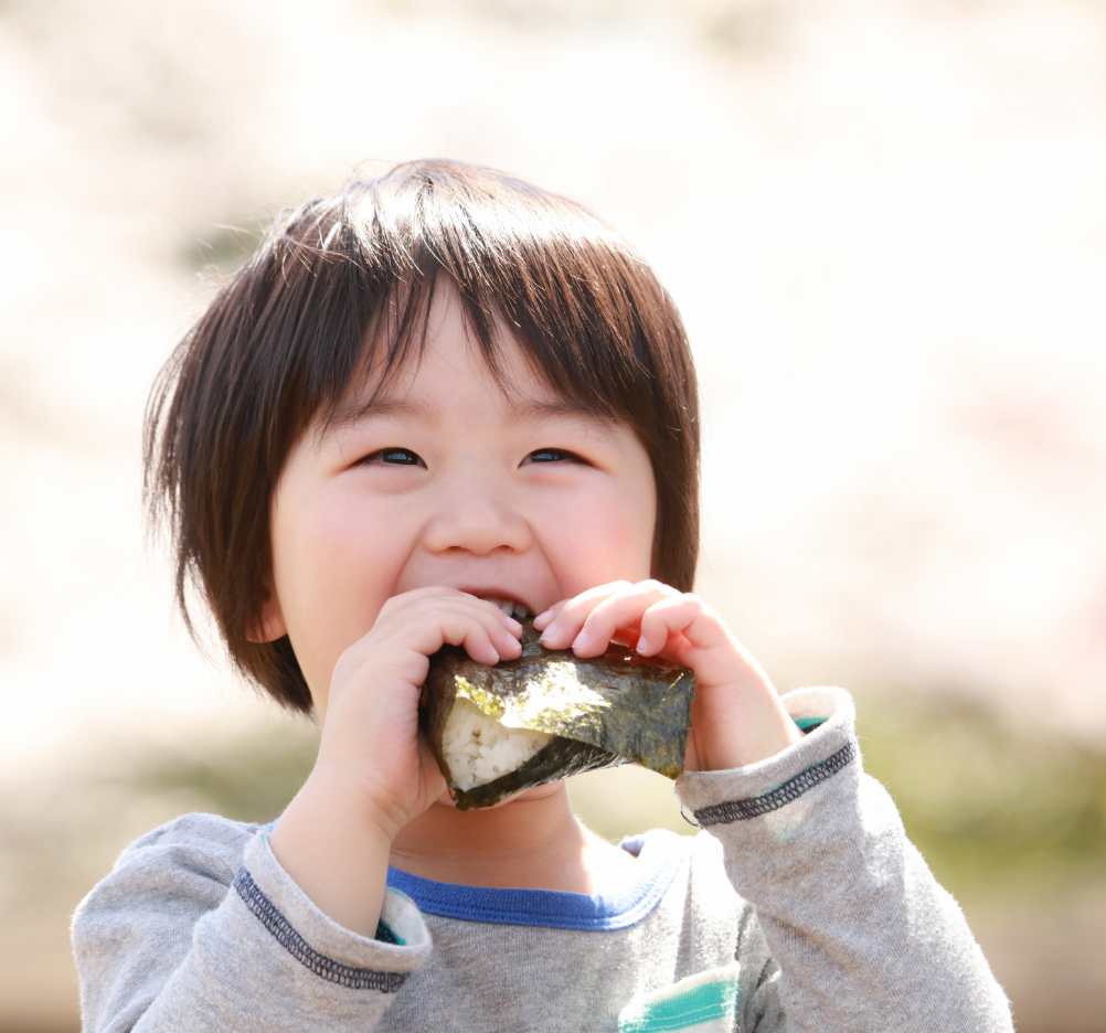 お茶碗を手に食事をする子ども