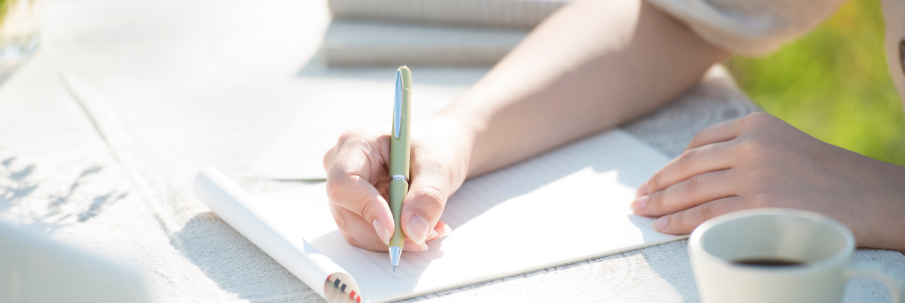 ノートに書きものをしている手元